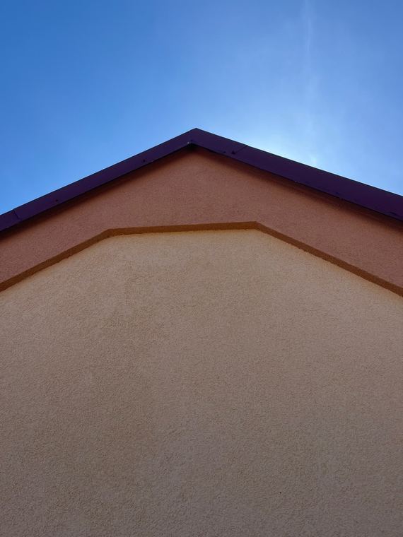 Detail dokončeného štítu s hladkou fasádní omítkou