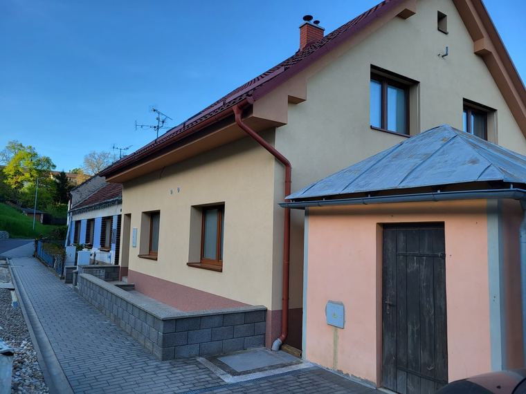 Menší hospodářský objekt s obnovenou fasádou a dřevěnými vraty