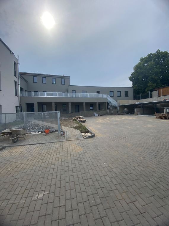 Komerční areál s dokončovanými fasádami a zpevněnými plochami
